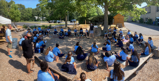 A group of people sitting on the ground outside

Description automatically generated with medium confidence